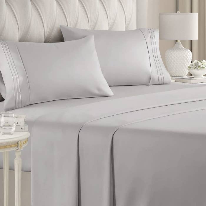 gray bedsheets with piping detail on a made bed