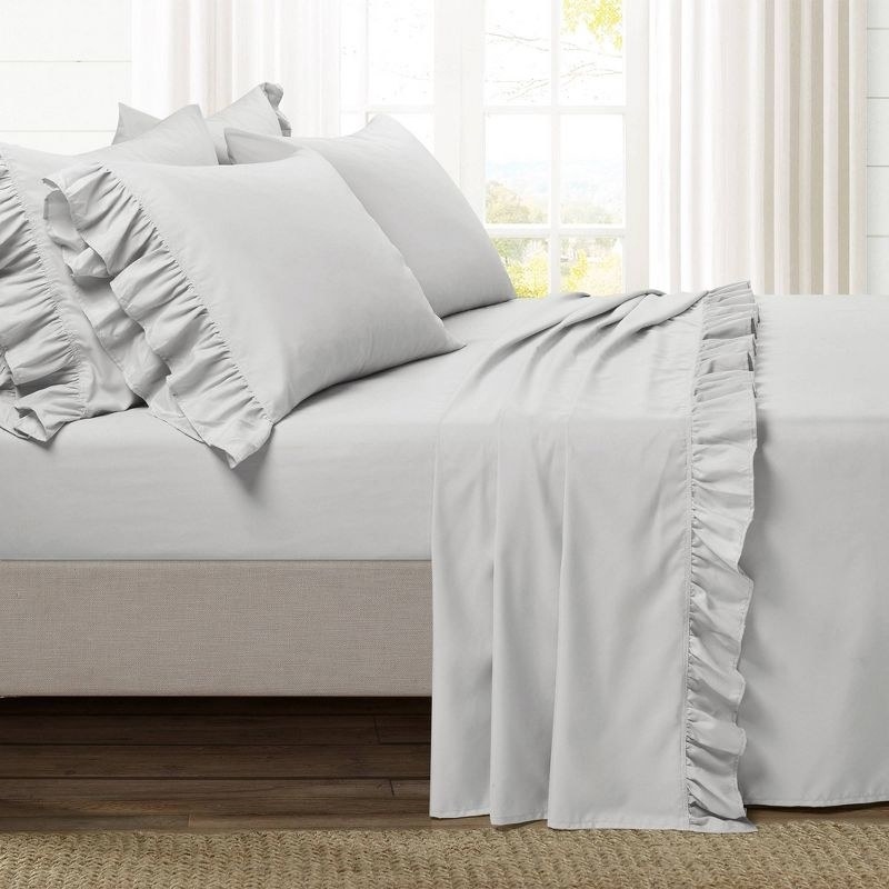 grey bedding with ruffled edges on a bed