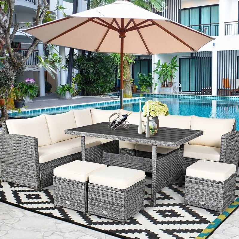 a seven-piece outdoor dining room set with elongated sofa and umbrella