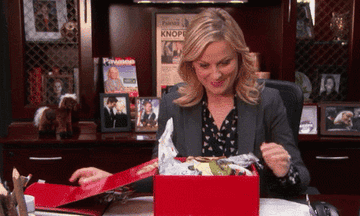 Leslie Knope opens a present and says, &quot;It&#x27;s trash. It&#x27;s filled with trash. Maybe there&#x27;s something at the bottom here. No just trash&quot;