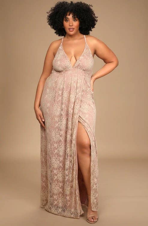 An image of a model wearing a blush lace-up maxi dress with a side slit and plunging v-neckline