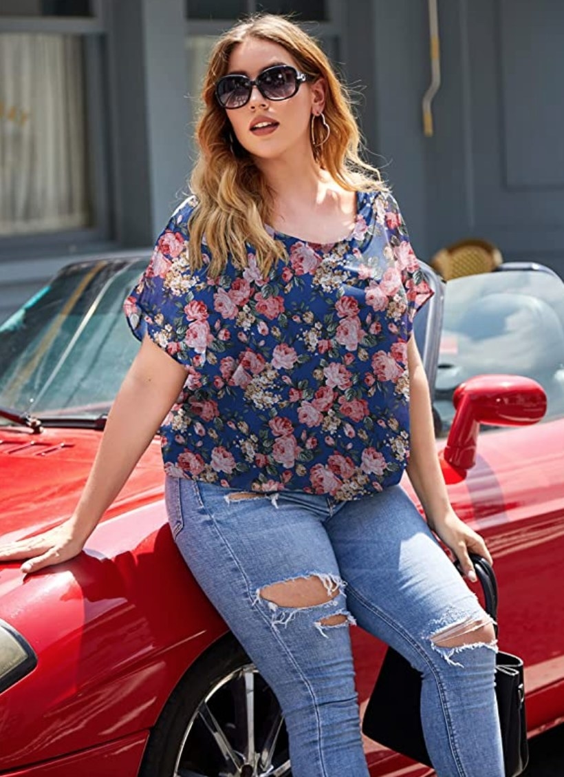 A model wearing a blue floral scoop neck tunic top