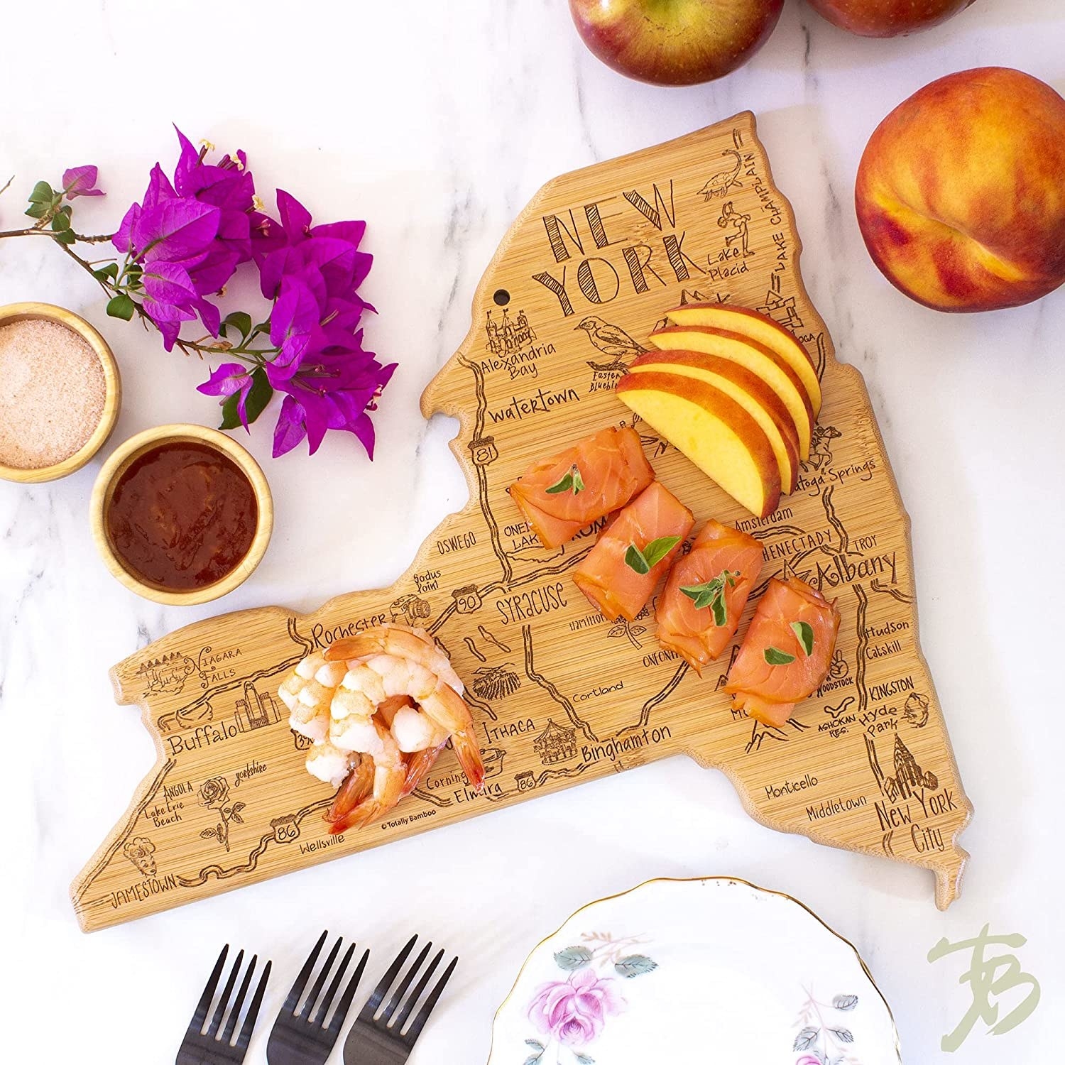 New York State-shaped charcuterie board with engravings of cities/towns and popular attractions under shrimp pieces and smoked salmon rolls