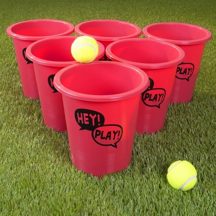 tennis balls going into large red buckets