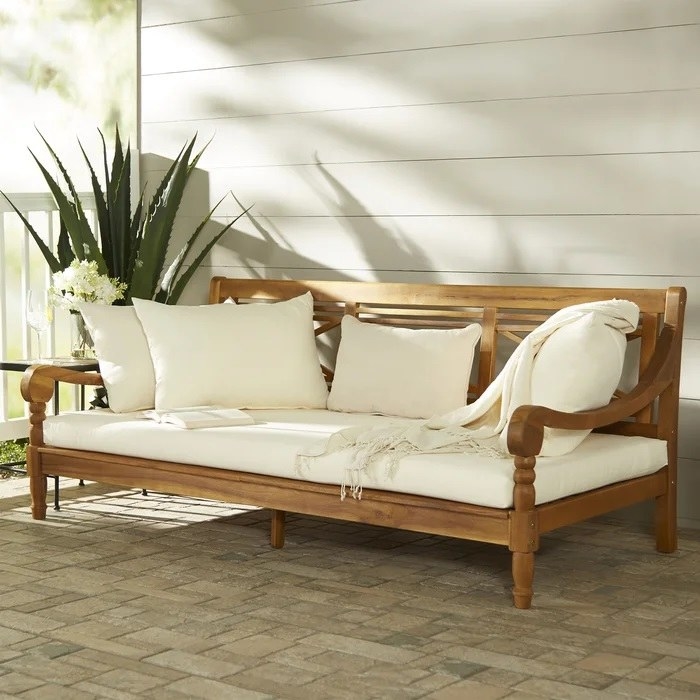 wide wood daybed with beige cushions