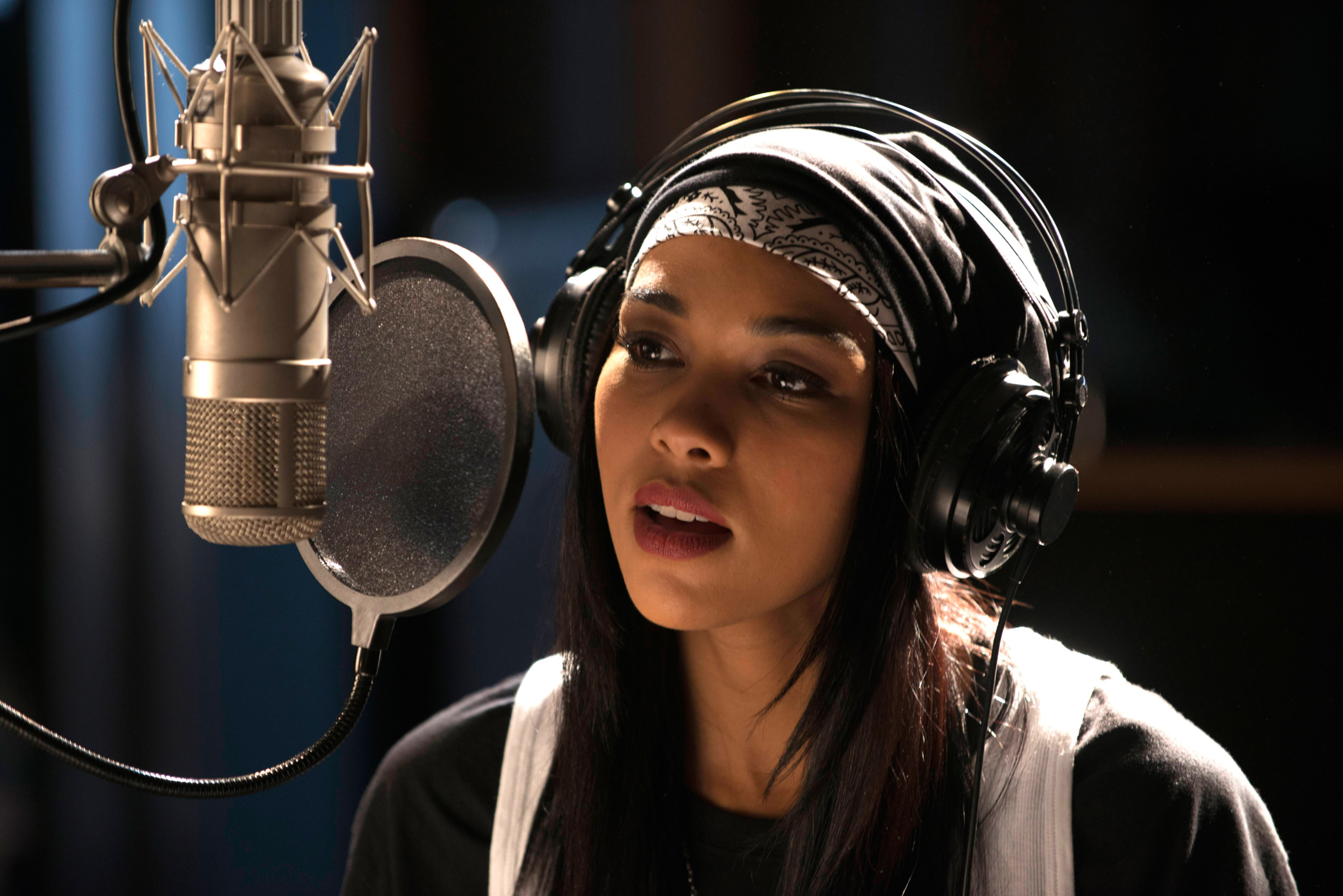 Alexandra in the role sitting behind a mic in a recording studio