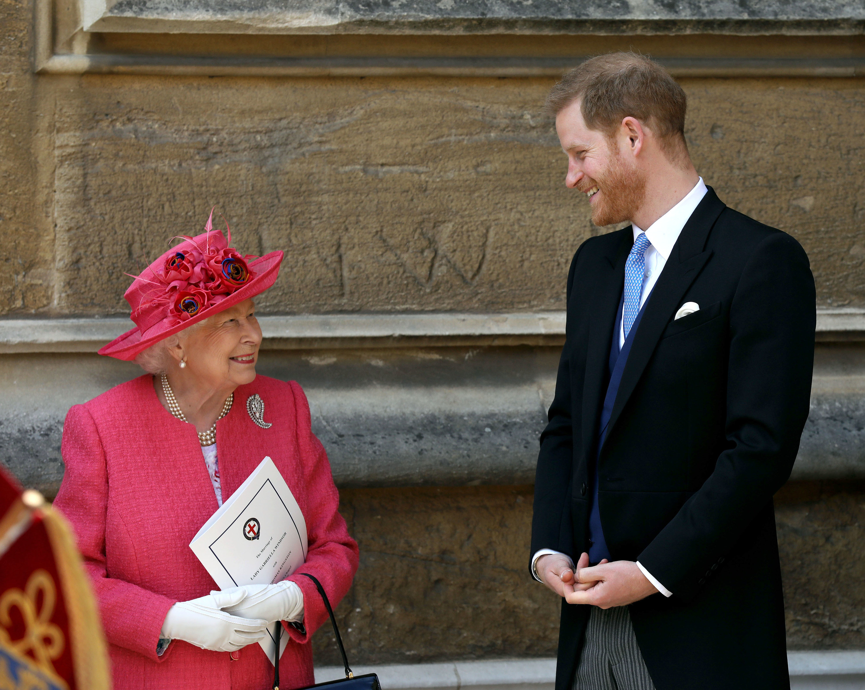 The queen and harry look at each other with a smile