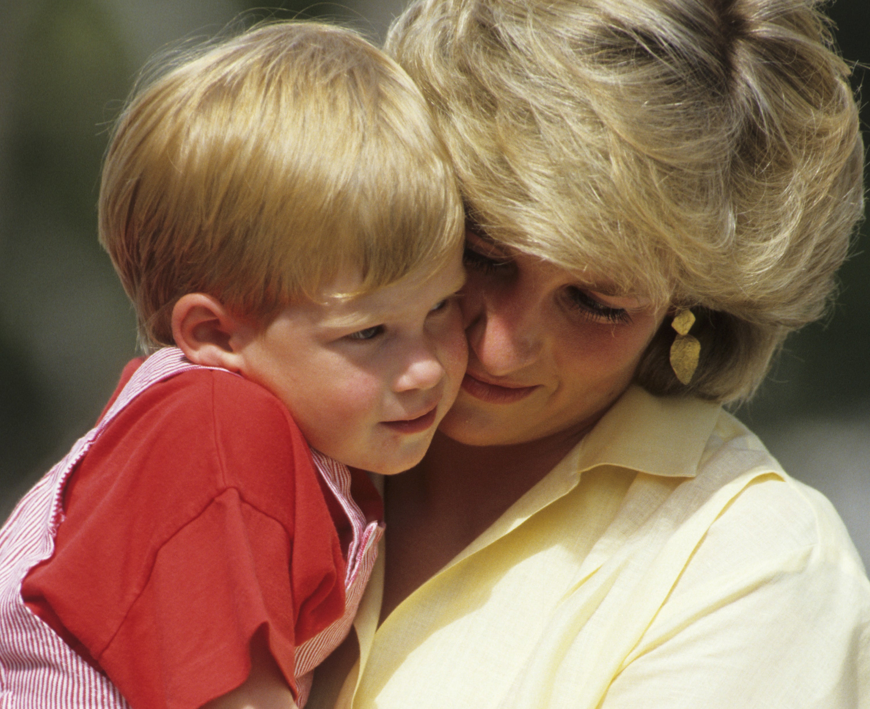 Diana holds a young harry in her arms