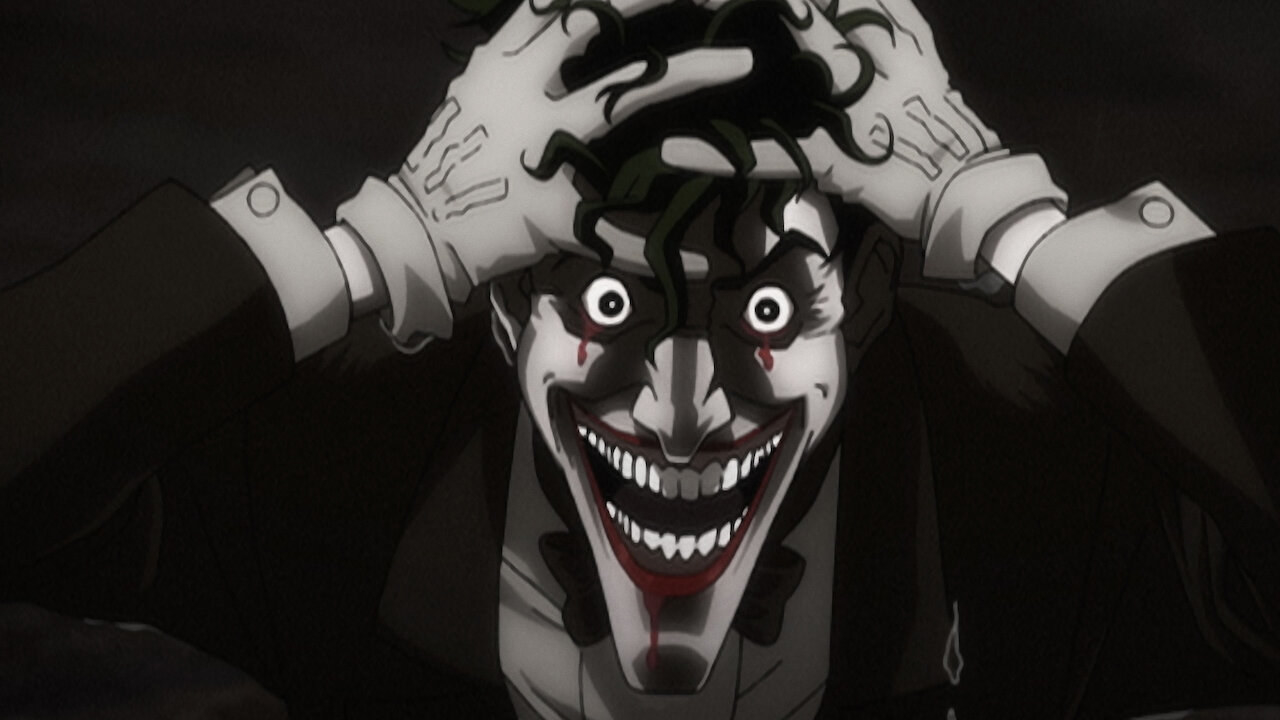 joker with wide eyes and a wide mouth, all teeth showing holds his head with both hands