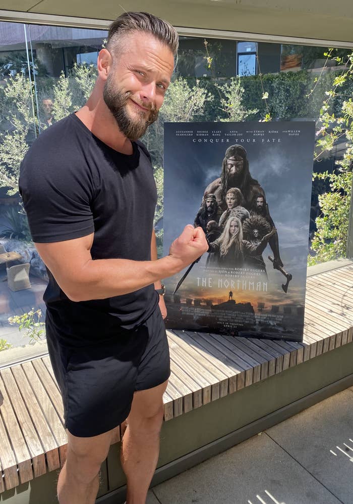 Lygback flexing in front of the movie poster
