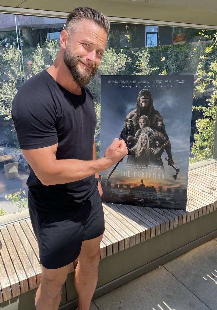 Lygback flexing in front of the movie poster