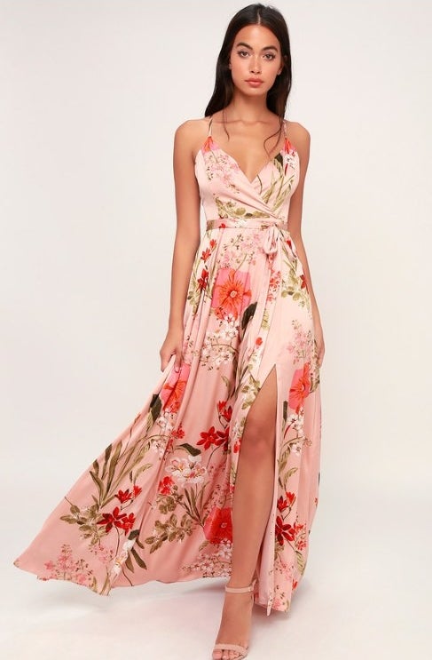 An image of a model wearing a floral satin maxi dress with adjustable spaghetti straps that crisscross at the back