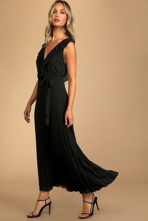 An image of a model wearing a black chiffon maxi dress with a V-neck and open back