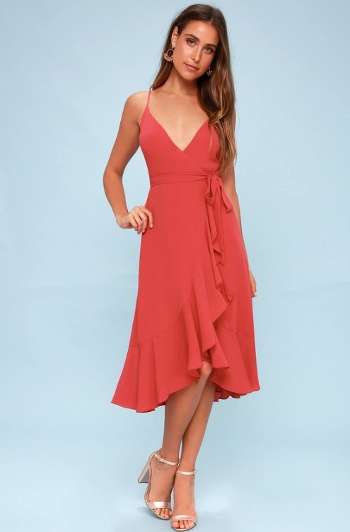 An image of a model wearing a berry pink wrap midi dress featuring adjustable straps and a high-low hem