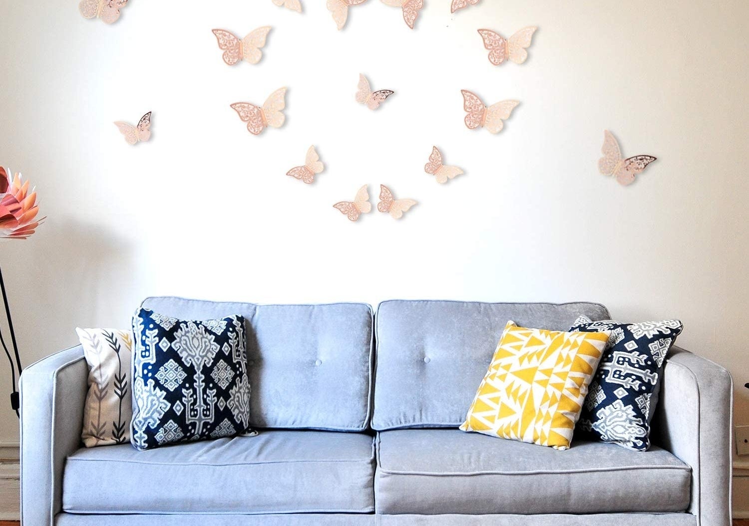 The butterfly decals on a wall above a couch