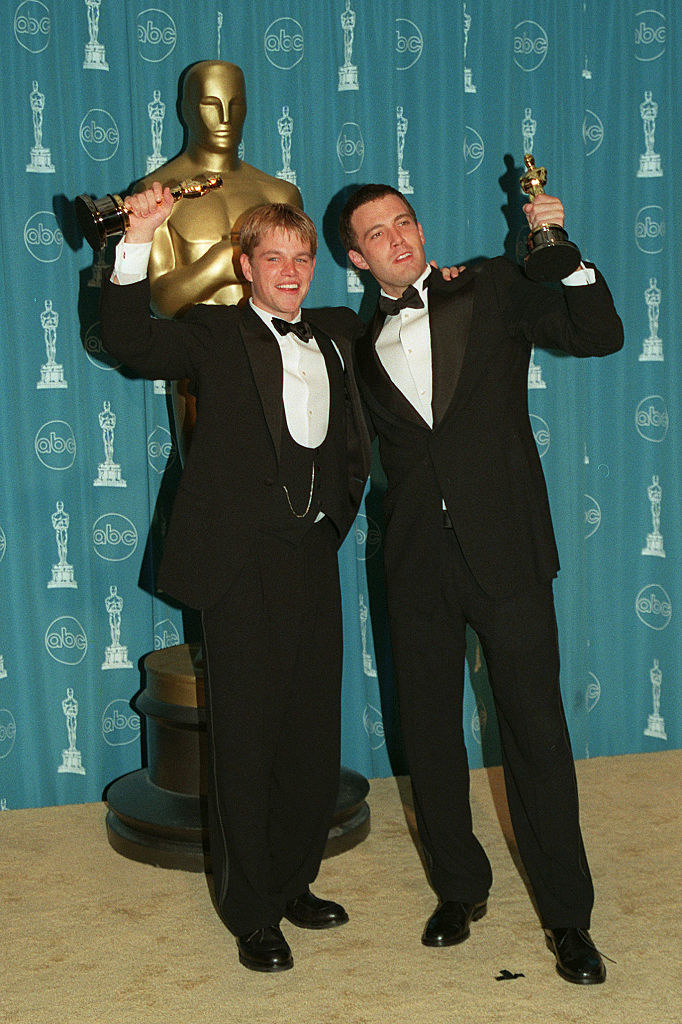 Matt Damon and Ben Affleck holding their Oscars.