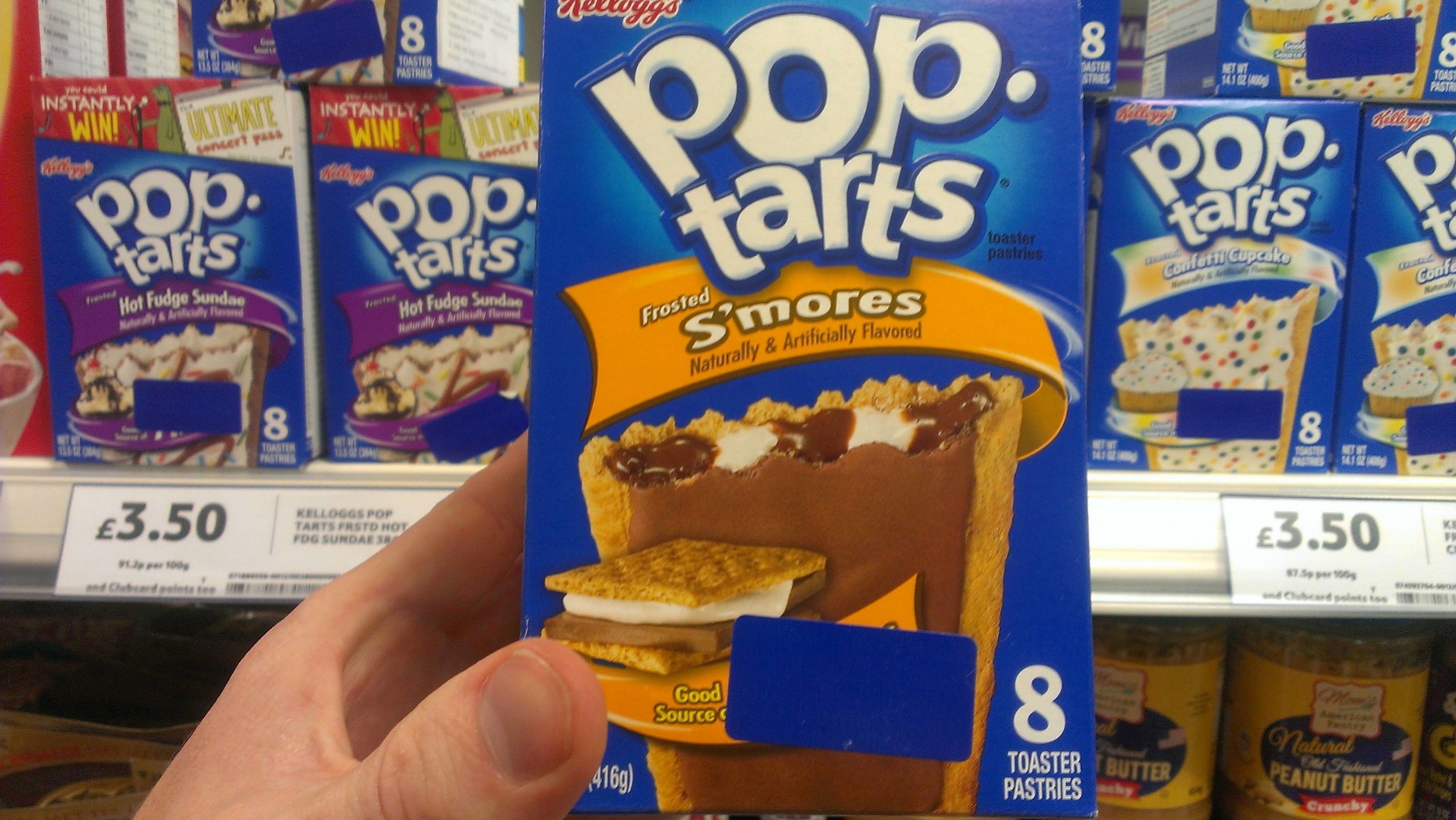 Someone holds up a box of S&#x27;mores Pop-Tarts with other flavors on the shelf and the price 3.50 in pounds sterling