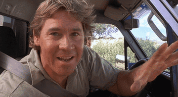 Steve Irwin leaning out of his car window and winking