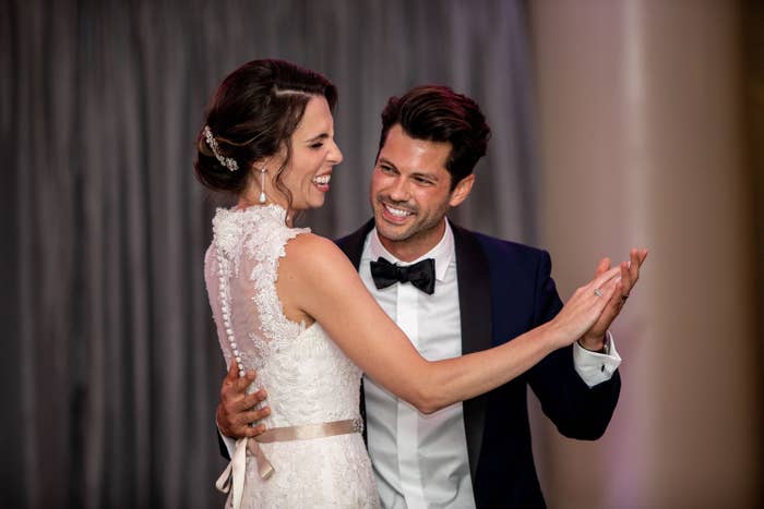 A husband and wife dancing at their wedding, looking happy