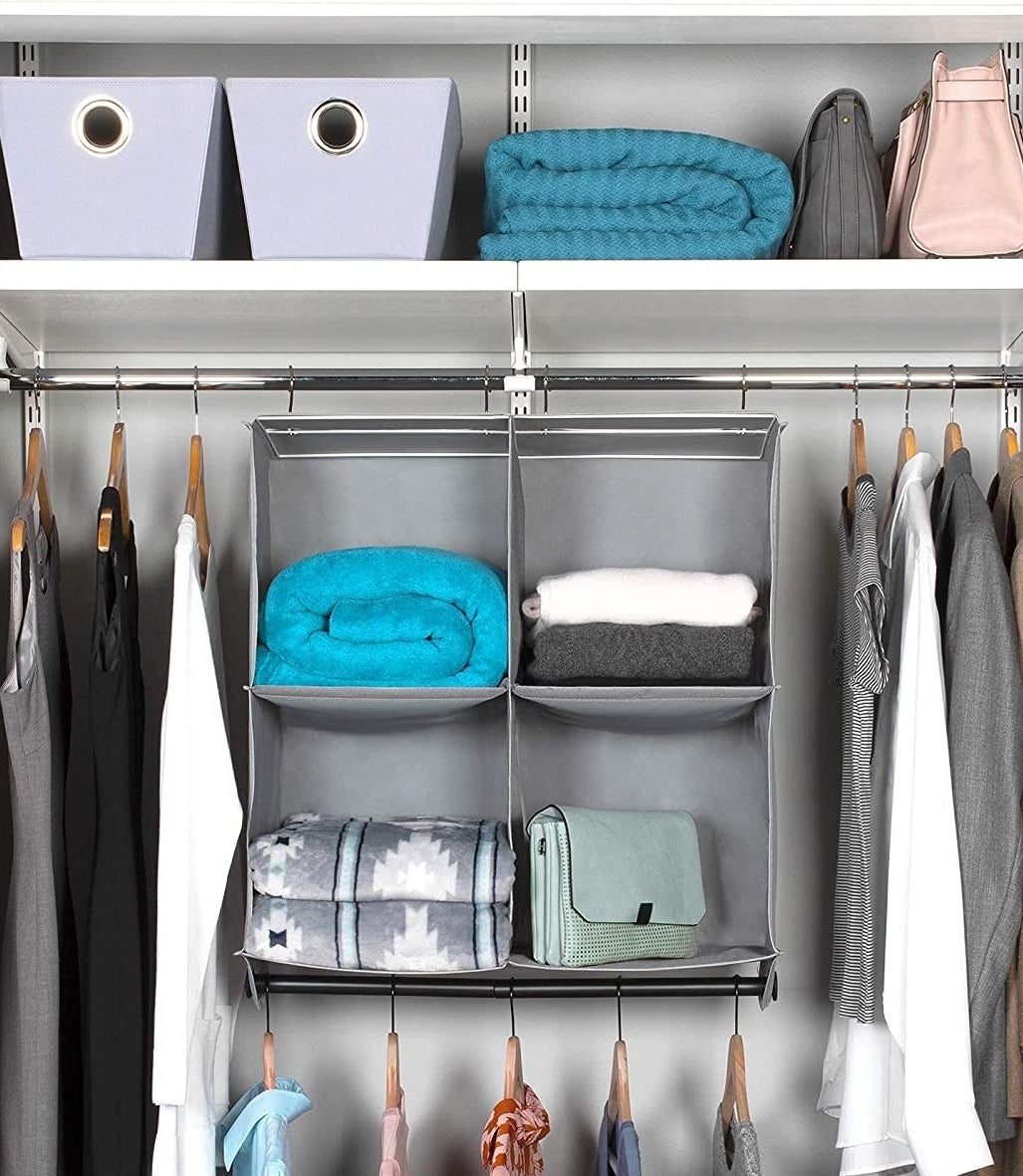 a hanging fabric shelf with four compartments in a closet