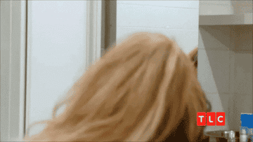 A GIF of someone trying to put on a dress