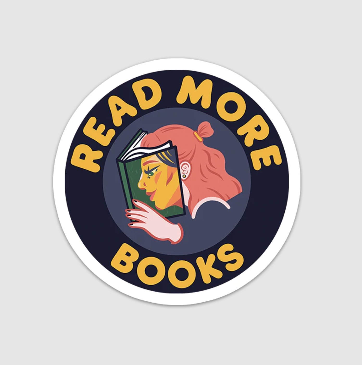 the circular sticker showing person with shoulder length hair and head buried into book with text &quot;read more books&quot; radiating out from center design