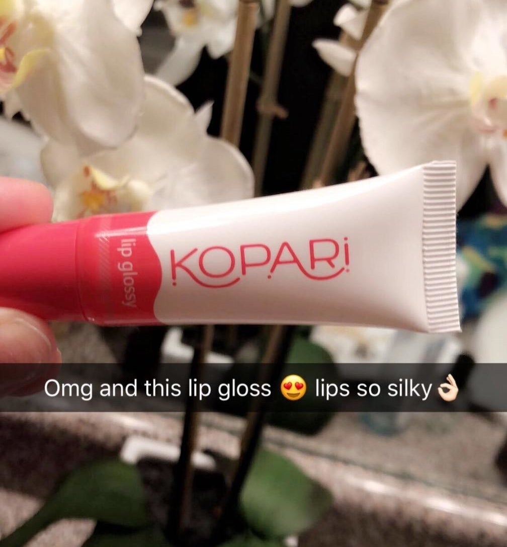 Reviewer holding Kopari lip gloss
