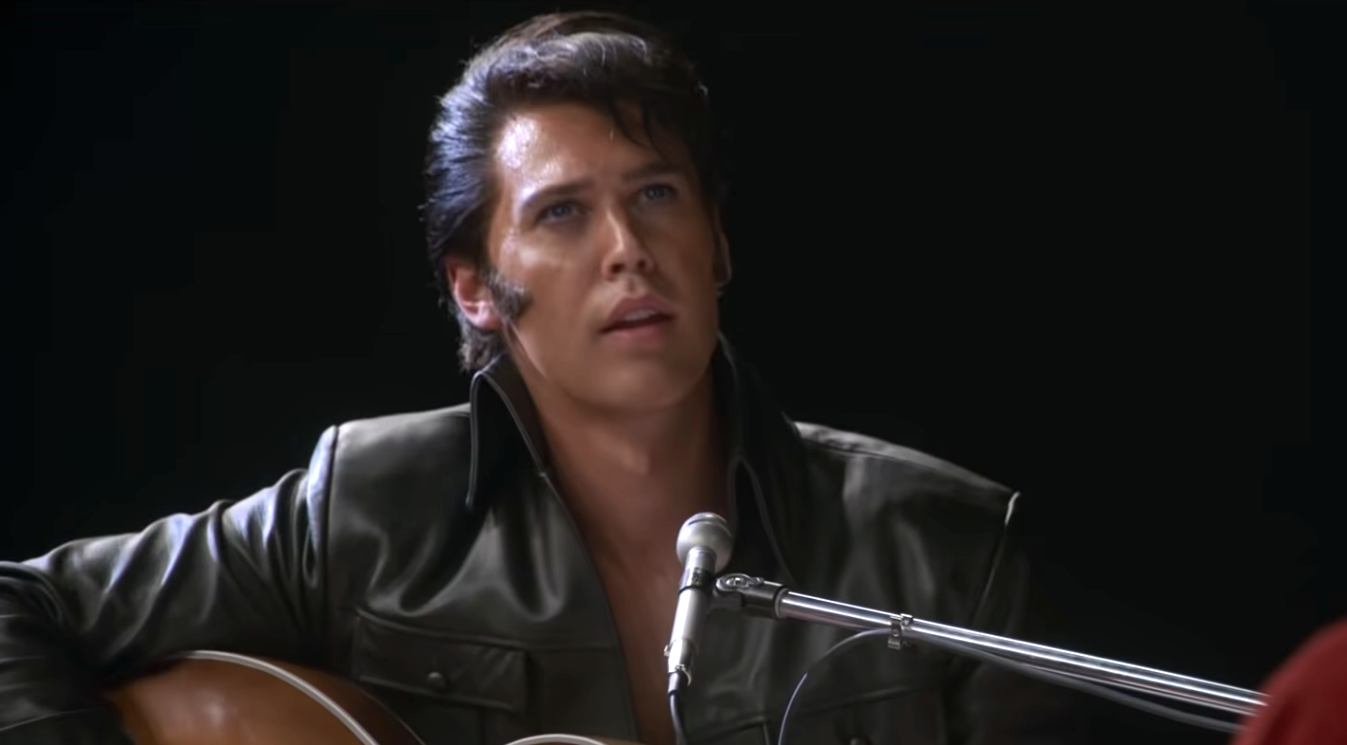 Austin Butler as Elvis Presley singing and playing the guitar