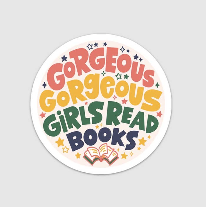 The white circular sticker with colorful letters reading gorgeous gorgeous girls read books with a book doodle at the bottom and lots of stars in the background