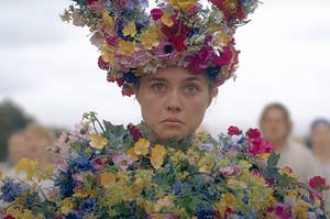 Florence Pugh frowning while she's covered in flowers as Dani in Midsommar