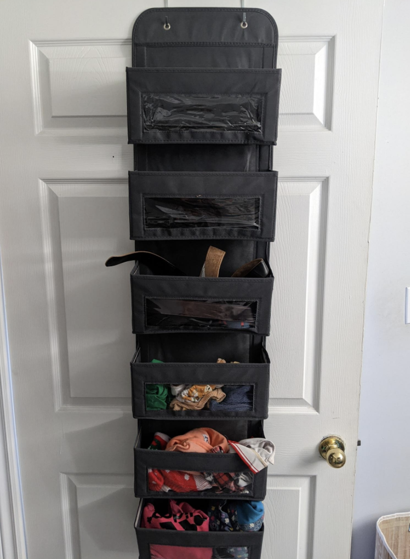 The organizer hanging over the door with half of the pockets full of stuff