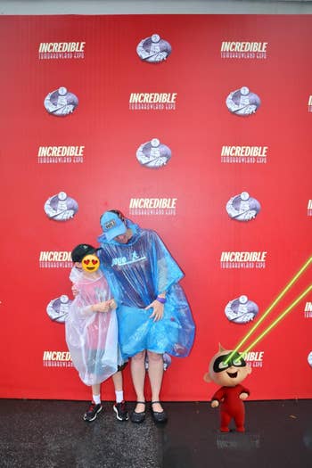 reviewer's photo wearing rain ponchos with their child at Disney