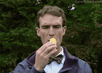 Bill Nye taking a bite of a Twinkie and nodding