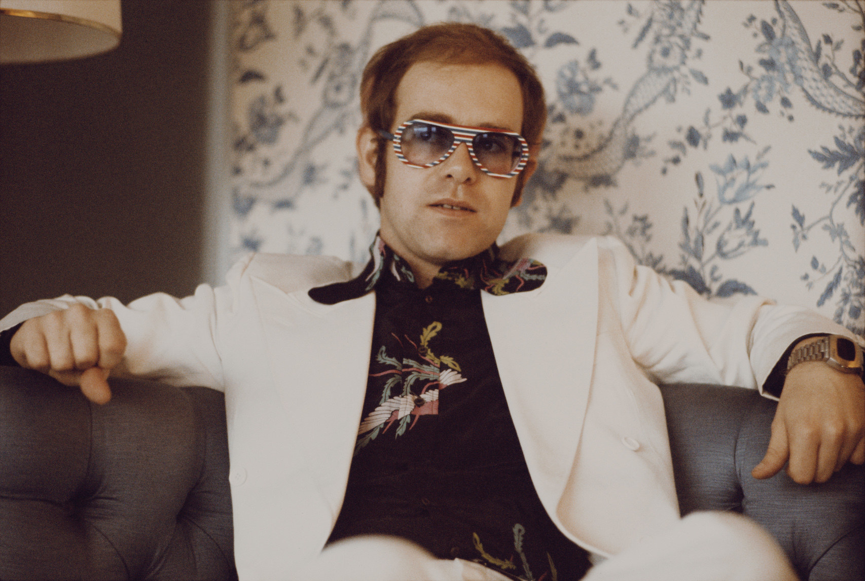 Elton John sitting on a couch