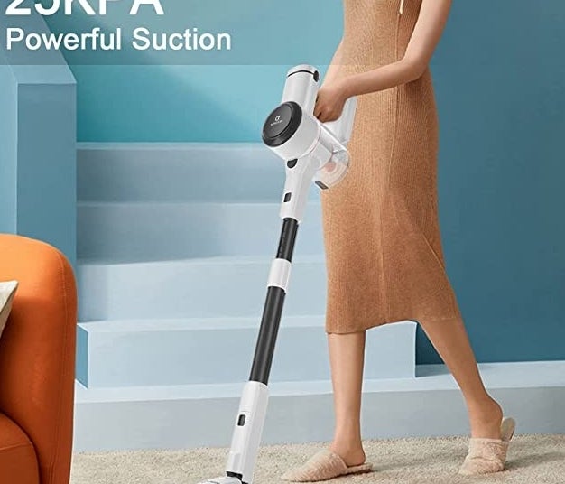 A person pushing the vacuum on a carpet
