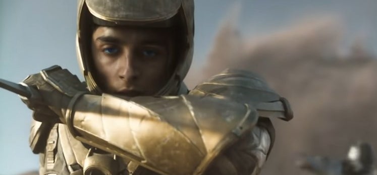 Paul holding a knife in golden Fremen armor in &quot;Dune: Part One&quot;