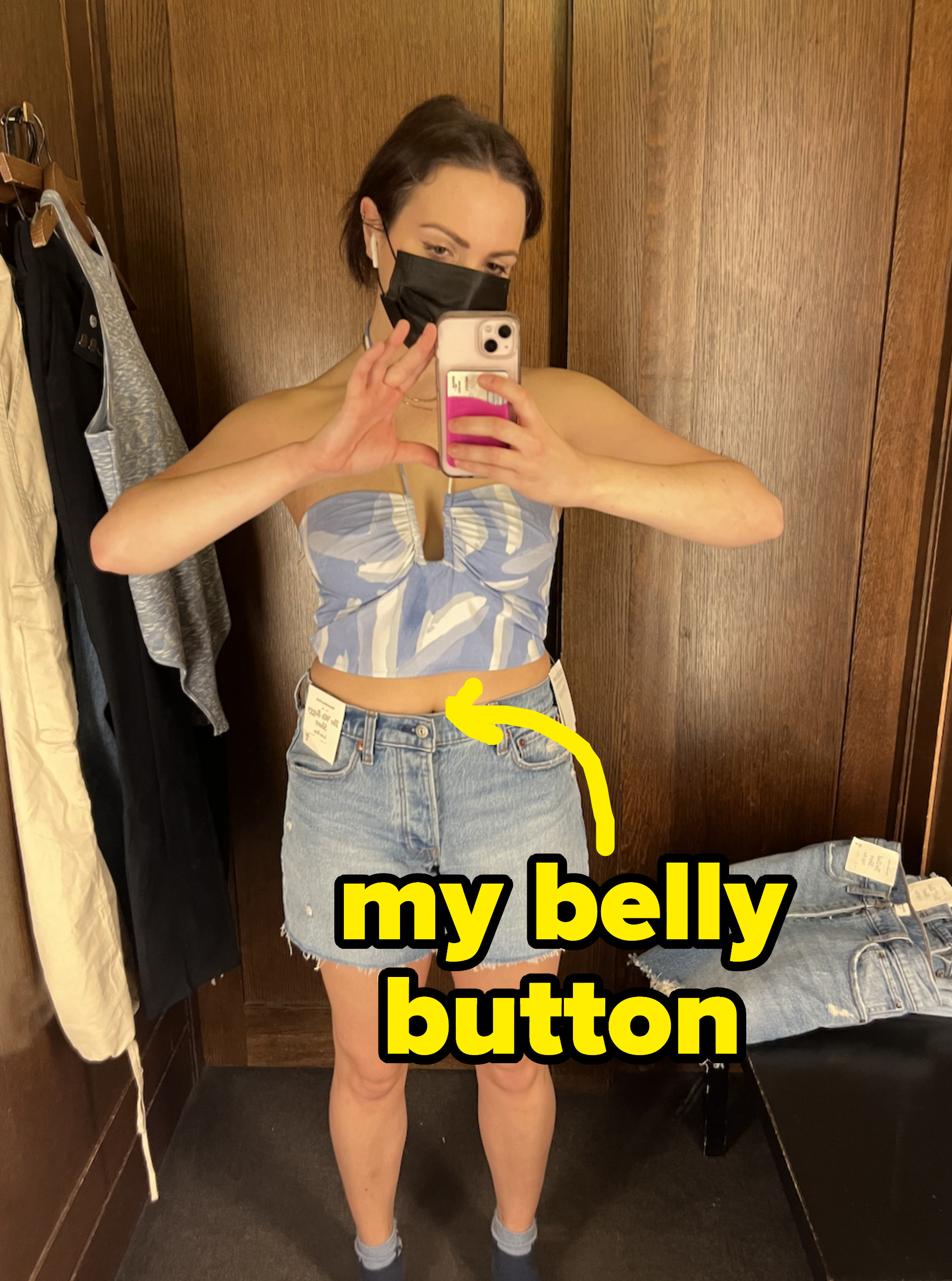 Hannah in a sleeveless top and jean short with arrow pointing to midriff, with text &quot;my belly button&quot;