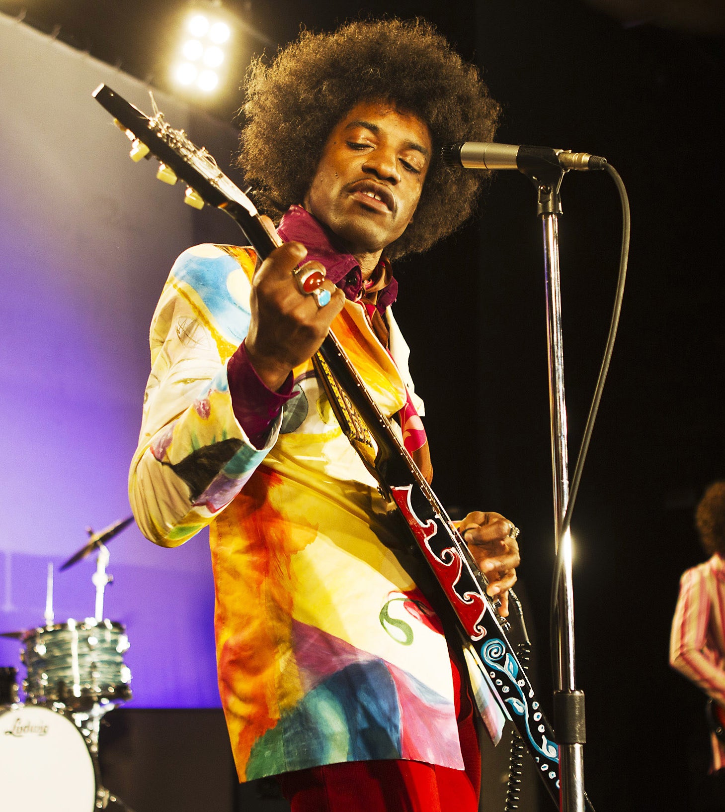 André 3000 dressed as Jimi Hendrix, playing guitar