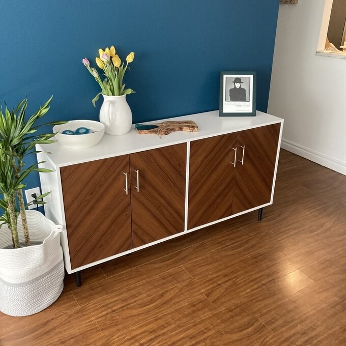 a reviewer photo of the sideboard against a teal wall