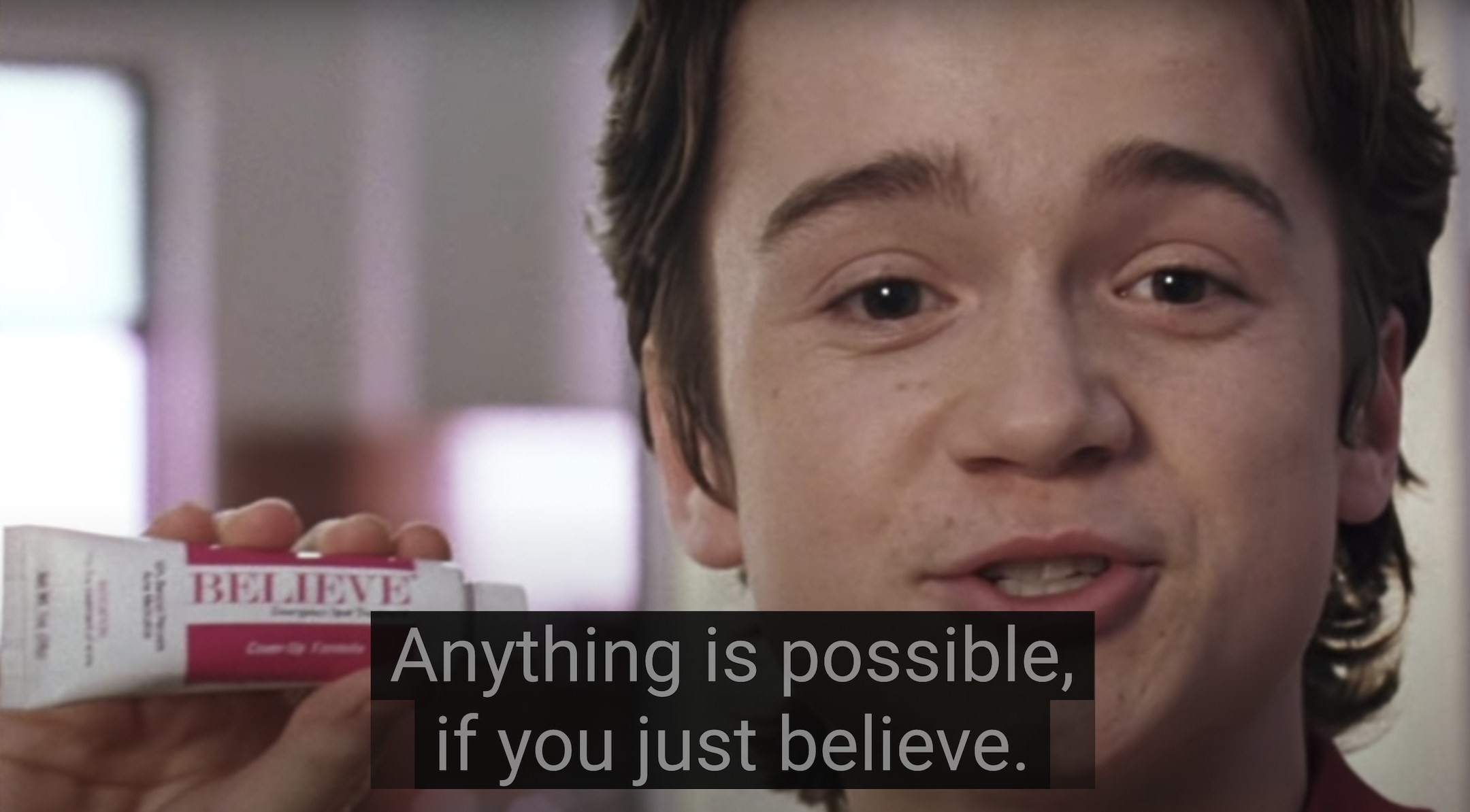 Carter is holding a bottle of a skin product called Believe and says, Anything is possible if you just believe