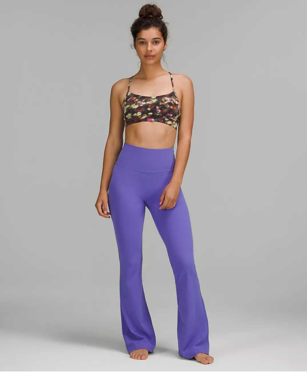 A person wearing a bralette and flared pants