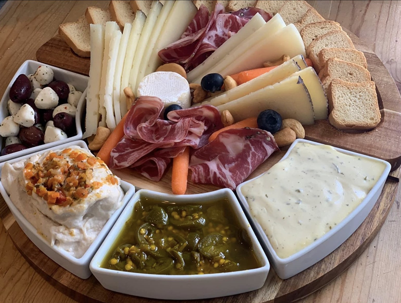 reviewer photo showing the cheese board set filled with cheese, crackers, meat, veggies and dips