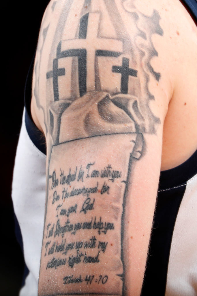 Crosses with a Bible verse tattooed on someone&#x27;s arm