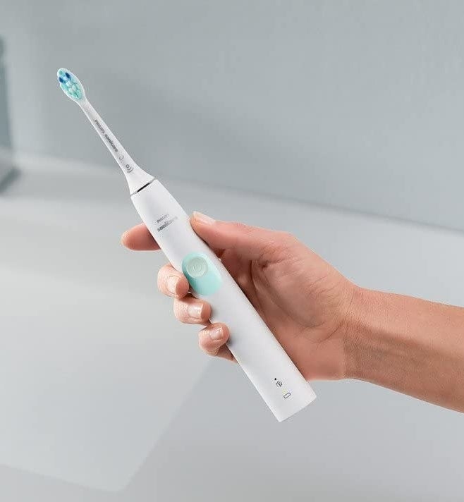 a person holding an electric toothbrush