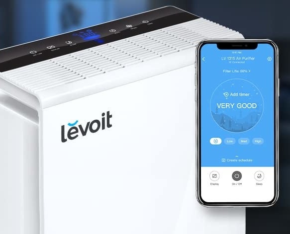an air purifier next to a phone open to the app that controls it