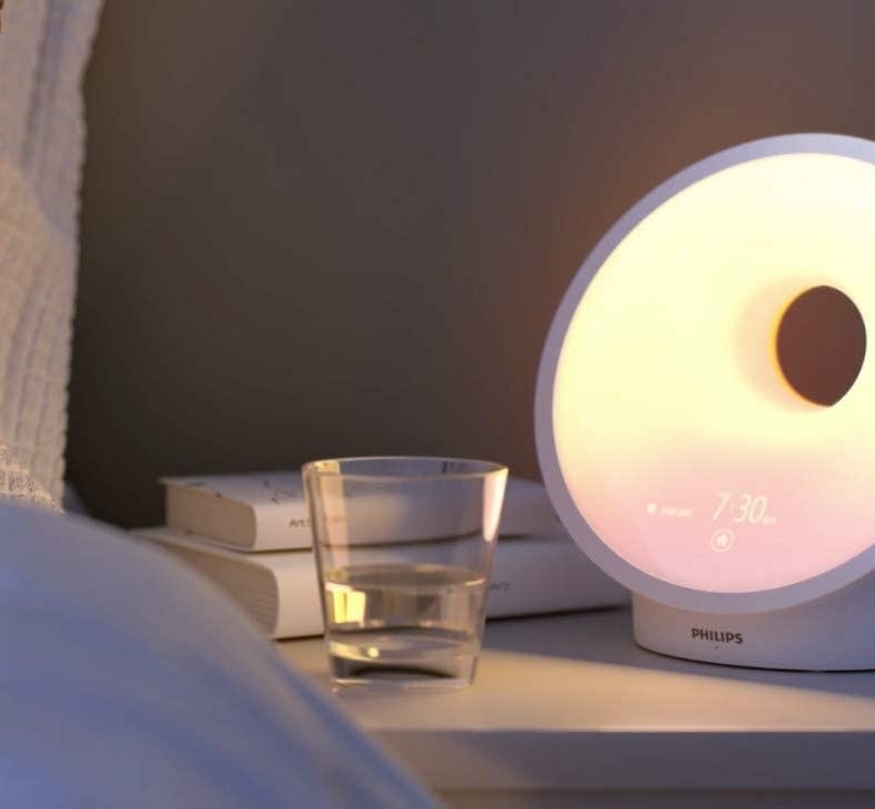 a round lamp alarm clock on a nightstand