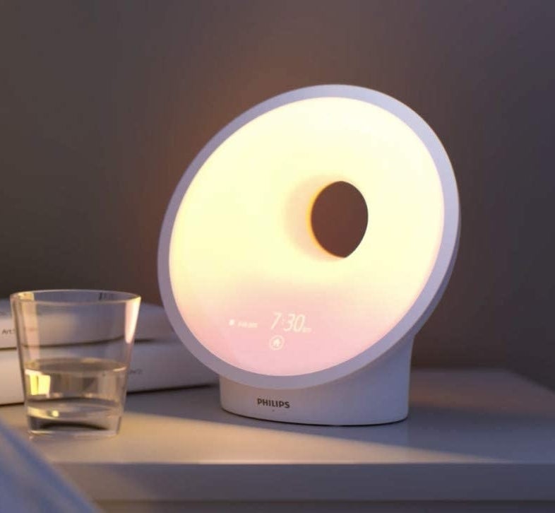 a round lamp alarm clock on a nightstand