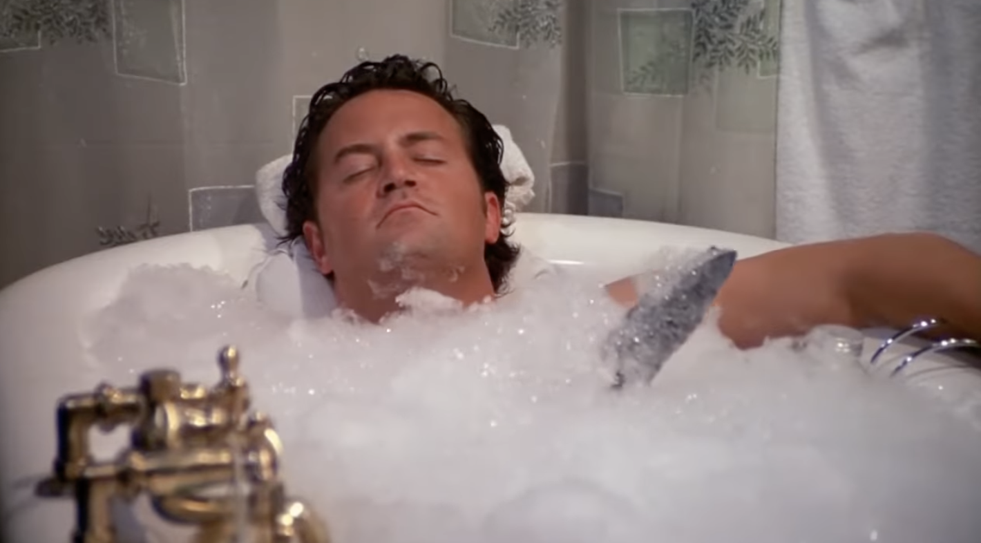 Chandler in a bubble bath holding his boat