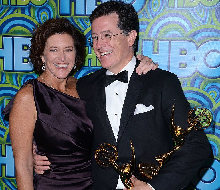 Stephen and Evelyn hugging while he holds two Emmys