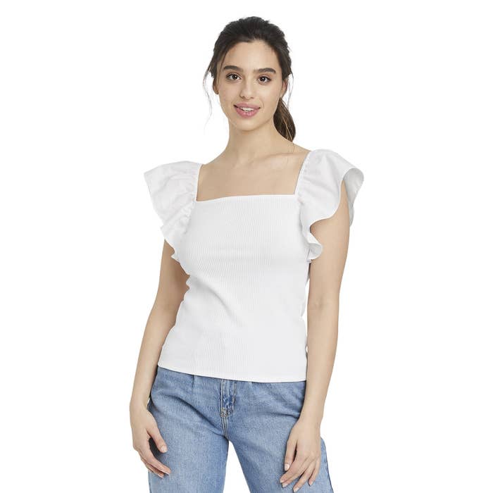 A woman wearing the Ruffle Top with jeans